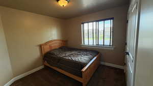 Bedroom featuring baseboards and dark colored carpet