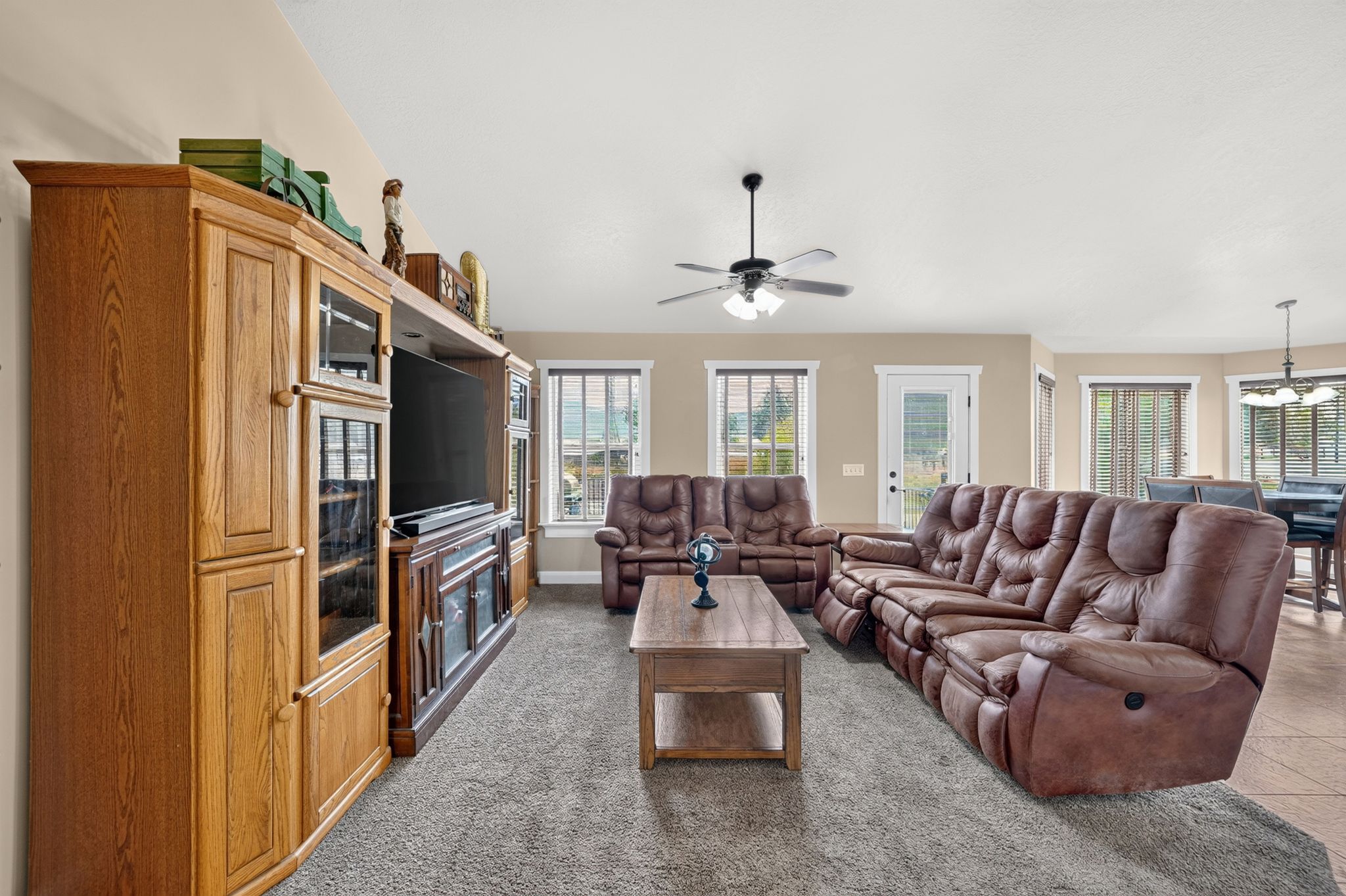 Spacious living area featuring neutral-toned walls and plush grey carpeting