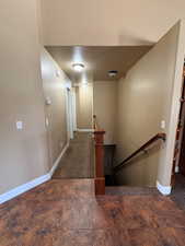 Hall featuring an upstairs landing and baseboards