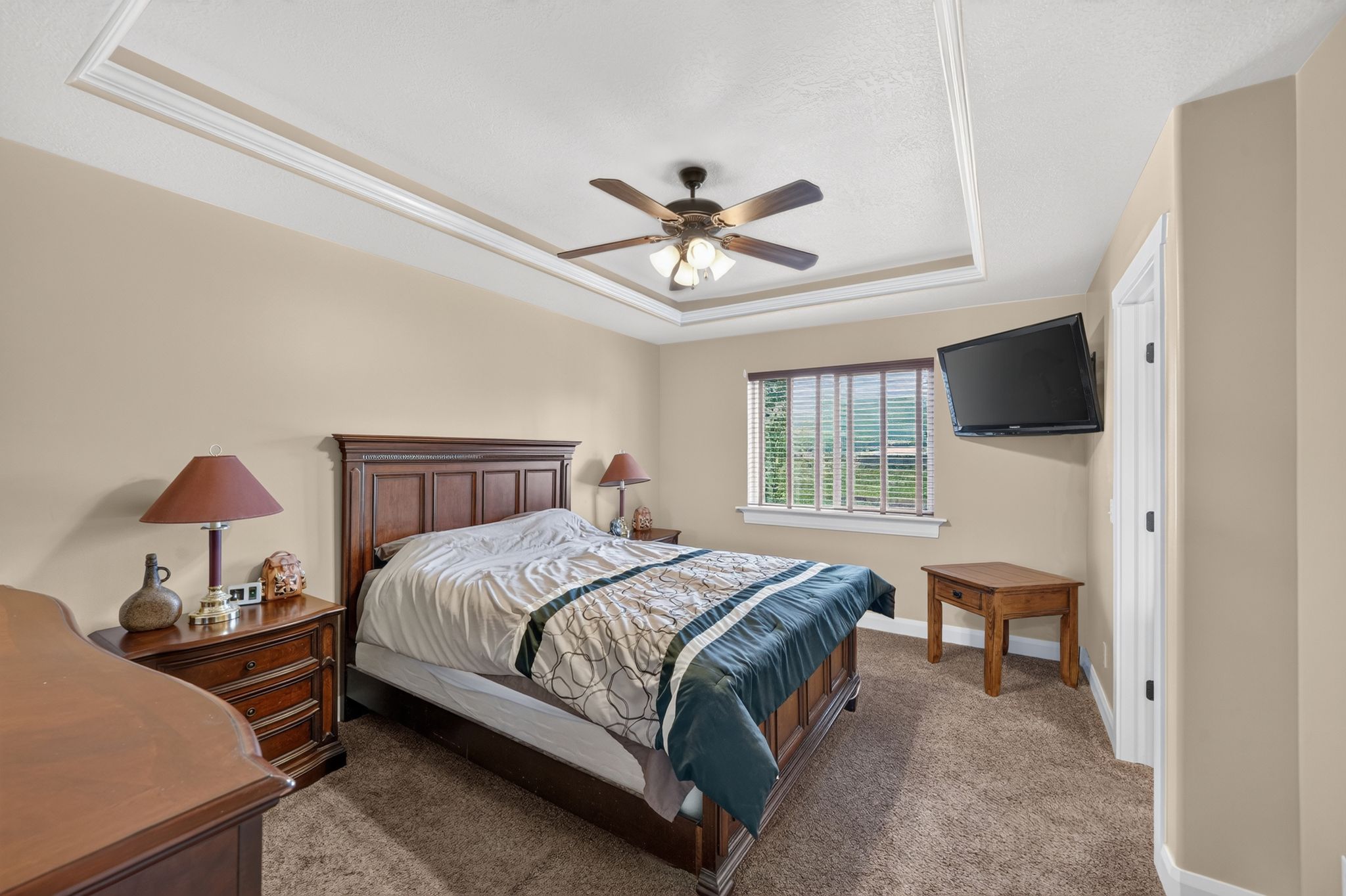 Recessed ceiling with layered crown molding and a ceiling fan with integrated lighting