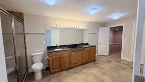 Full bathroom with double vanity and a shower stall