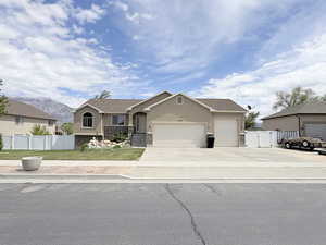 Single story home with a gate, an attached garage, stucco siding, and concrete driveway