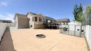 Fenced backyard featuring a gate, an outdoor fire pit, a deck, and a storage shed