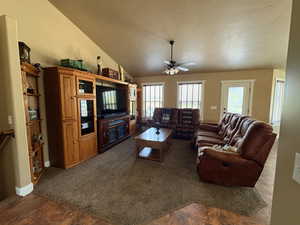Living room featuring a ceiling fan and dark colored carpet