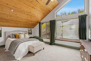 Bedroom featuring light colored carpet, a vaulted wood ceiling, and a ceiling fan