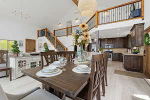 Dining space with hanging lights, light wood-style flooring, and lofted ceiling