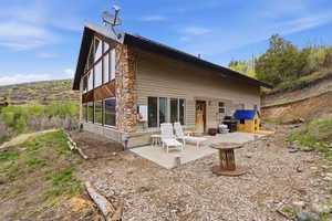 Rear view of house with a patio area and a sunroom