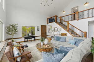 Living area with wood finished floors, suspended lighting, and vaulted ceiling