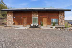 Rear view of house with stone siding and a metal roof