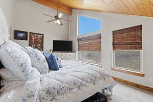 Bedroom featuring light carpet, wood ceiling, lofted ceiling with beams, and ceiling fan