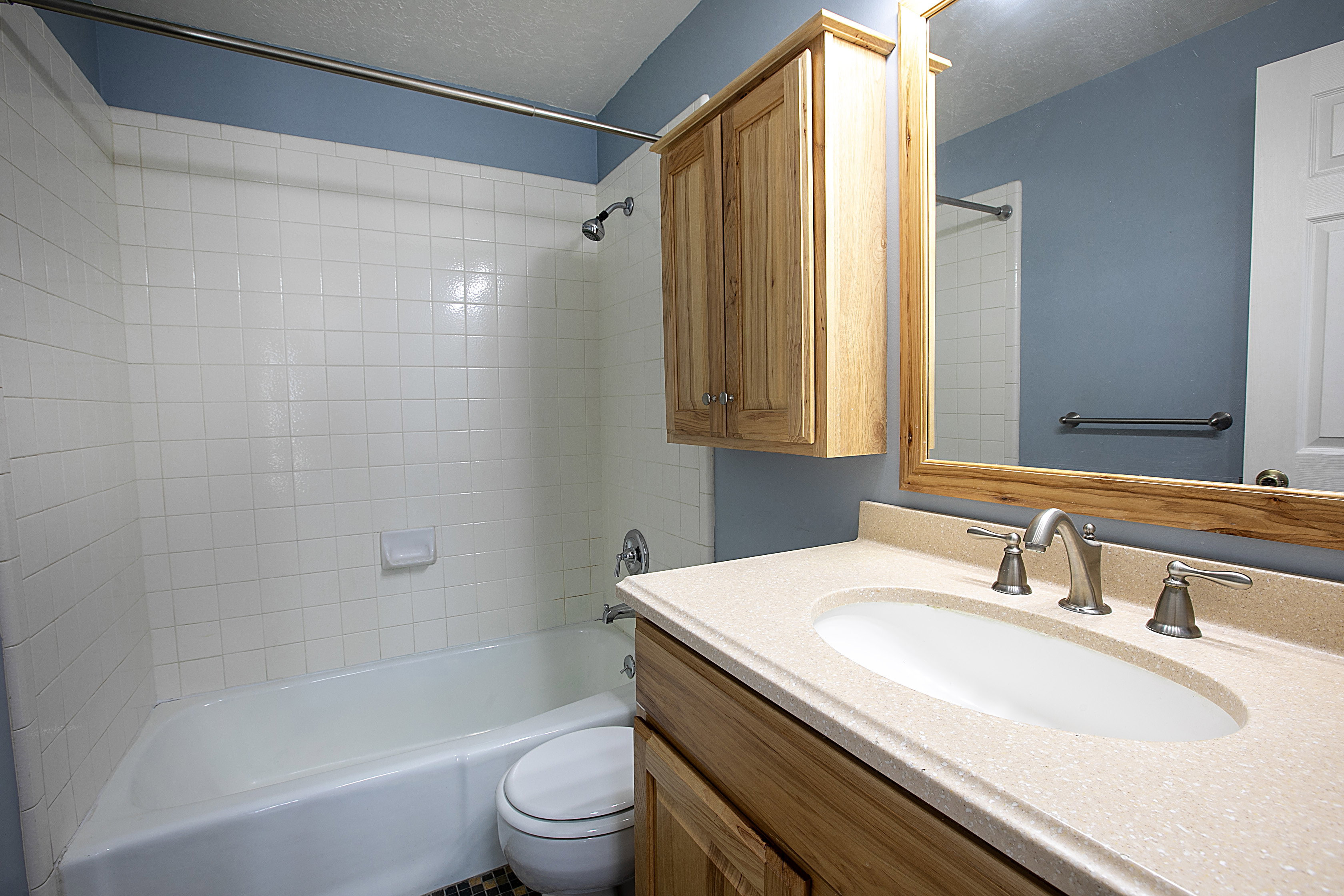 Full bath with vanity, a textured ceiling, and  shower combination