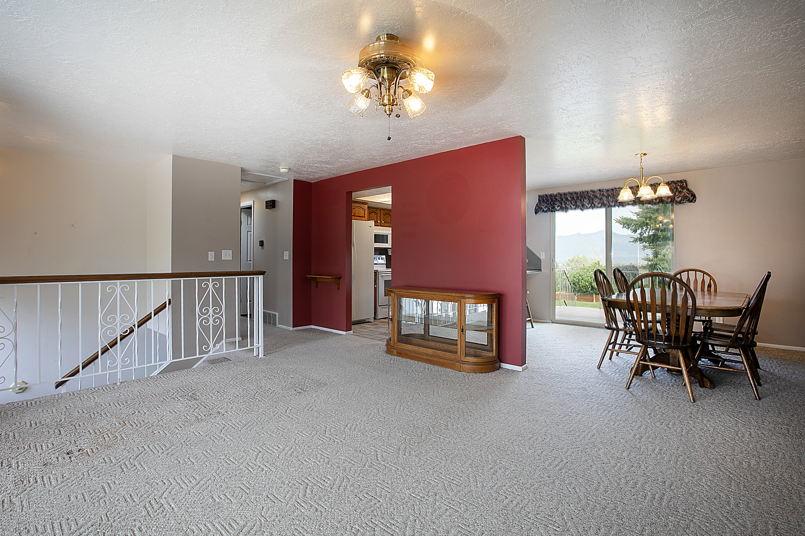 Carpeted dining space with hanging lights and a textured ceiling