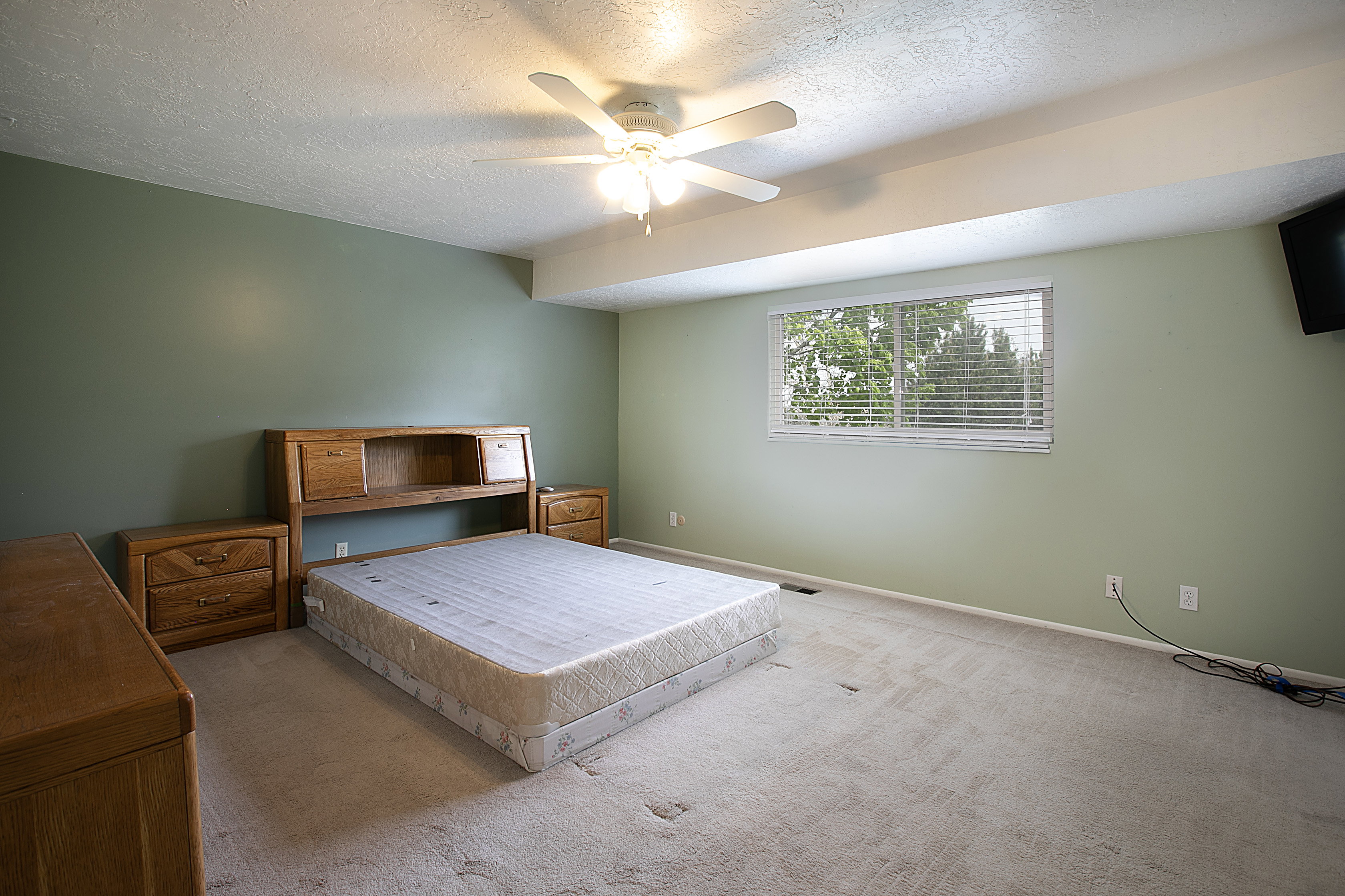 Bedroom with carpet, a textured ceiling, and ceiling fan