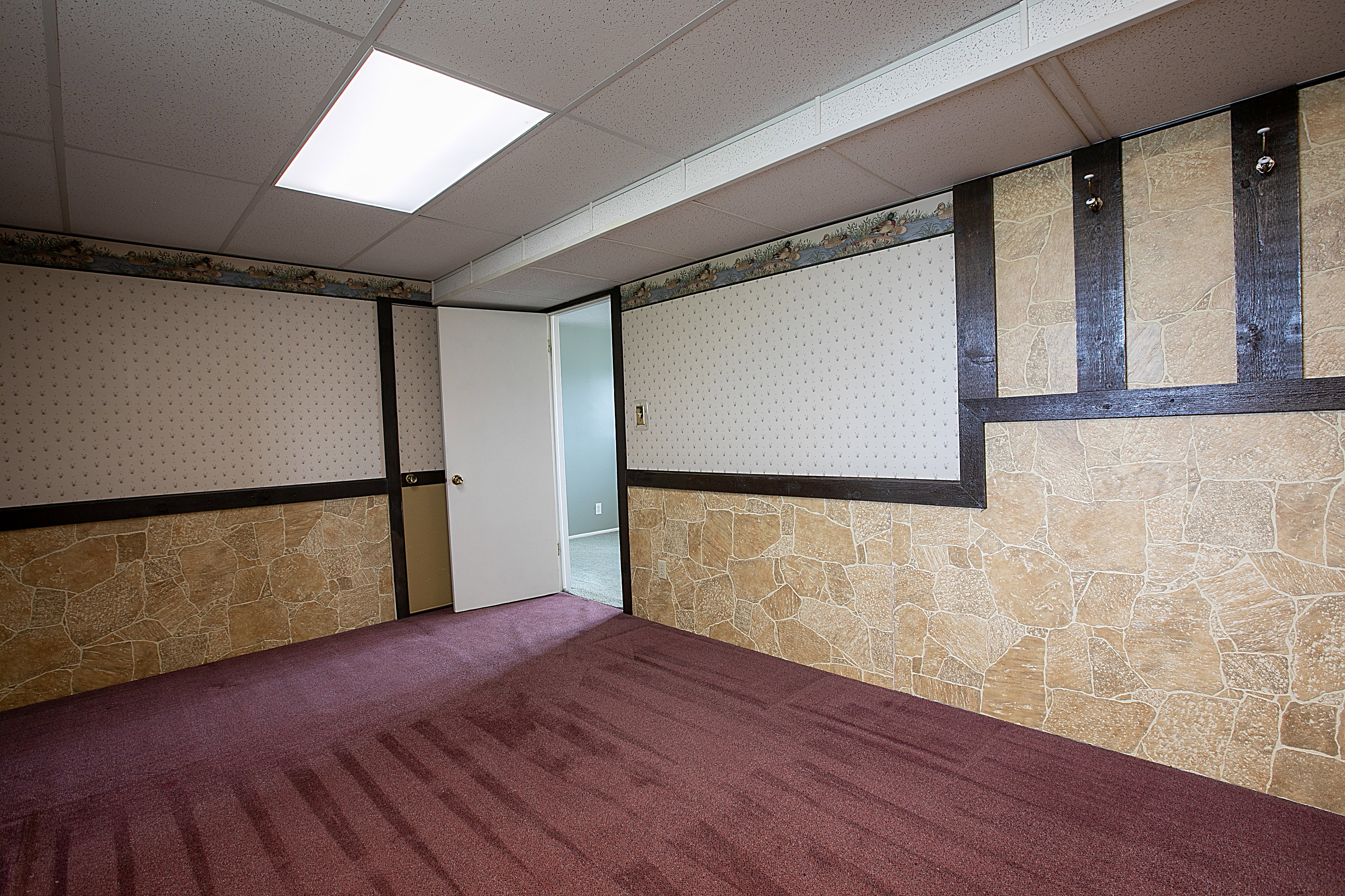 Empty room with a drop ceiling and carpet flooring
