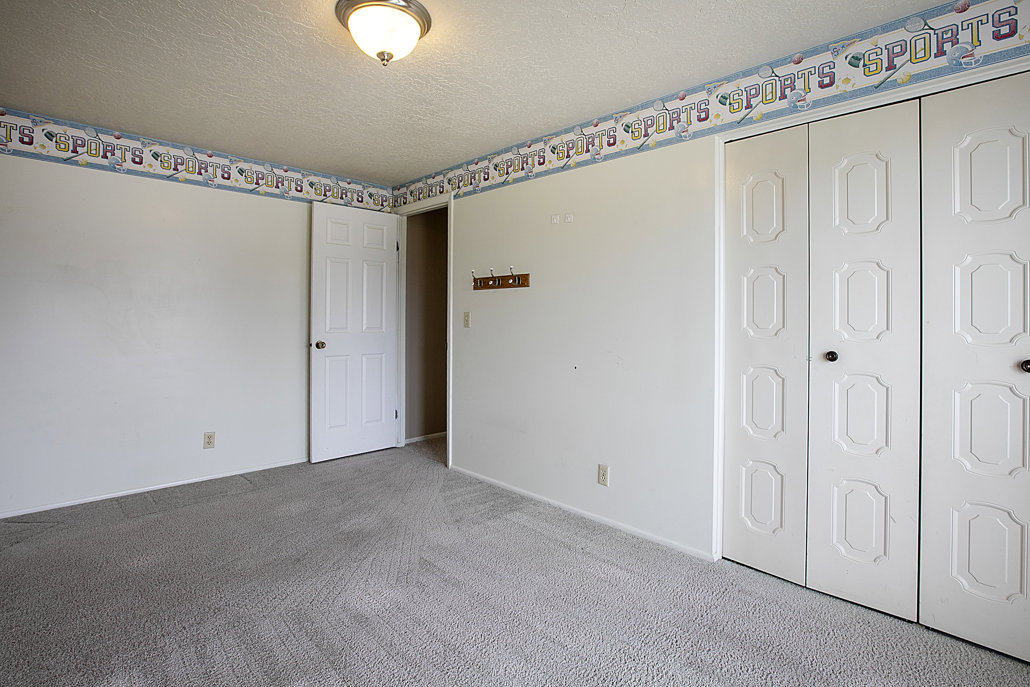Unfurnished bedroom with light carpet, a textured ceiling, and a closet