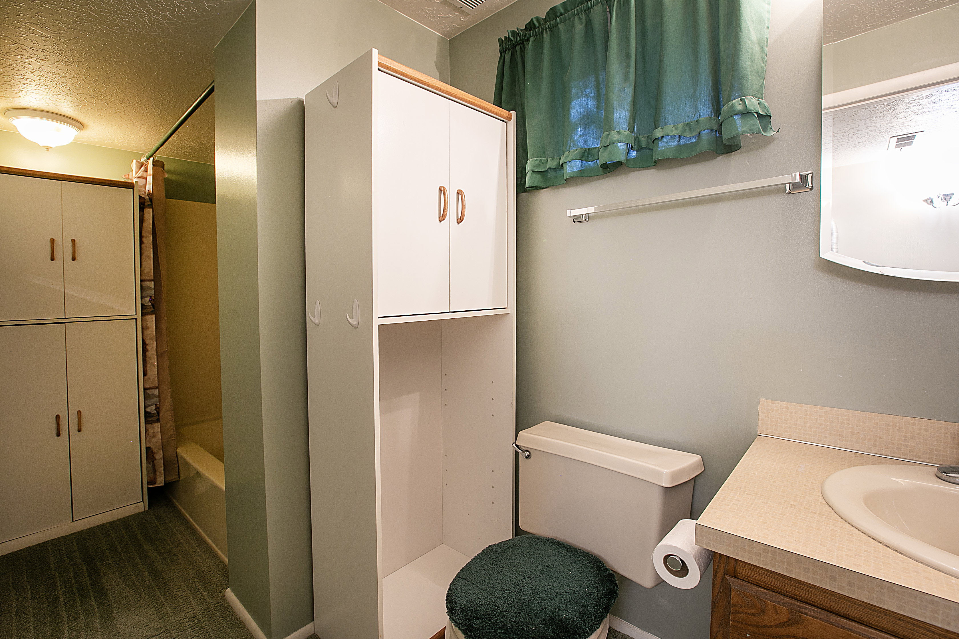 Full bath with a textured ceiling, vanity, and shower / bath combo with shower curtain