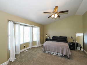 Bedroom featuring vaulted ceiling, a ceiling fan, and dark carpet