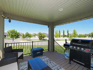 Wooden porch with a grill, a lawn, and a residential view
