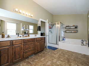 Full bathroom with double vanity, a shower stall, and a bath