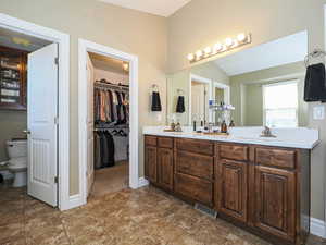 Bathroom with double vanity and a spacious closet