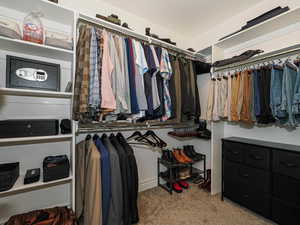 Walk in closet featuring light colored carpet