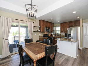Dining room with dark wood-style flooring and a chandelier