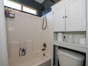 Bathroom featuring toilet and shower / tub combo with curtain