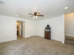 Empty room featuring carpet, a ceiling fan, recessed lighting, and a textured ceiling