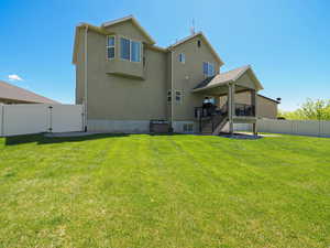 Rear view of property featuring a gate, a fenced backyard, a wooden deck, and stucco siding