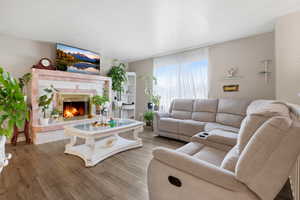 Living room with wood finished floors and a tiled fireplace