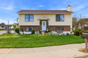 Raised ranch with brick siding and a chimney