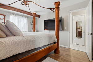 Bedroom featuring wood finished floors and baseboards