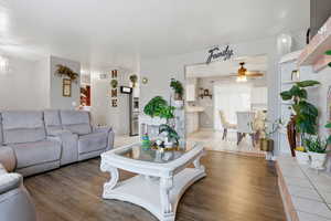 Living area with wood finished floors, a ceiling fan, and a chandelier
