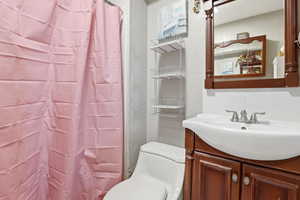 Full bath with vanity, a shower with curtain, and a textured wall