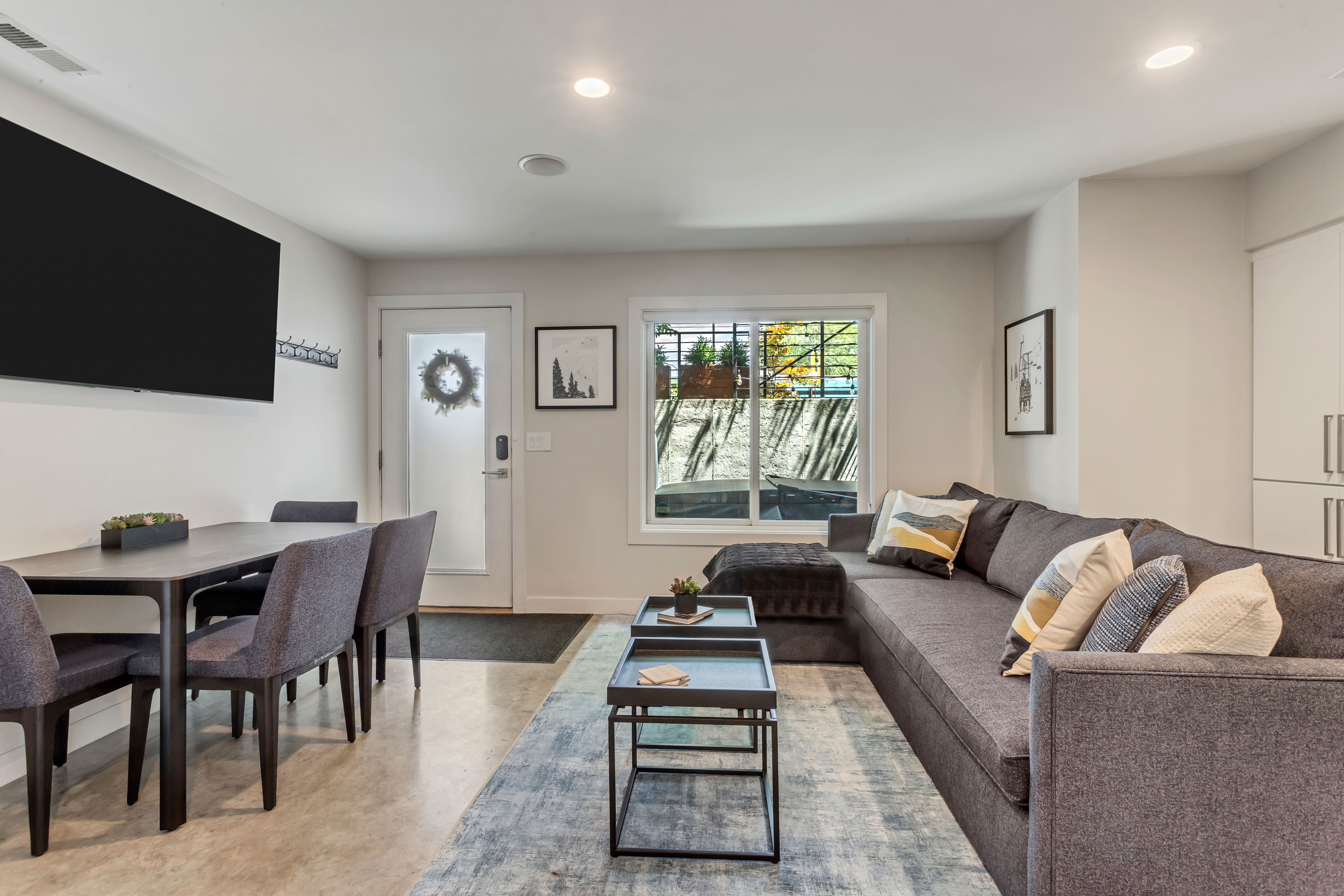 Living area with recessed lighting and finished concrete floors.  Outside entrance door pictured here.