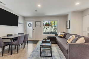 Living area with recessed lighting and finished concrete floors.  Outside entrance door pictured here.