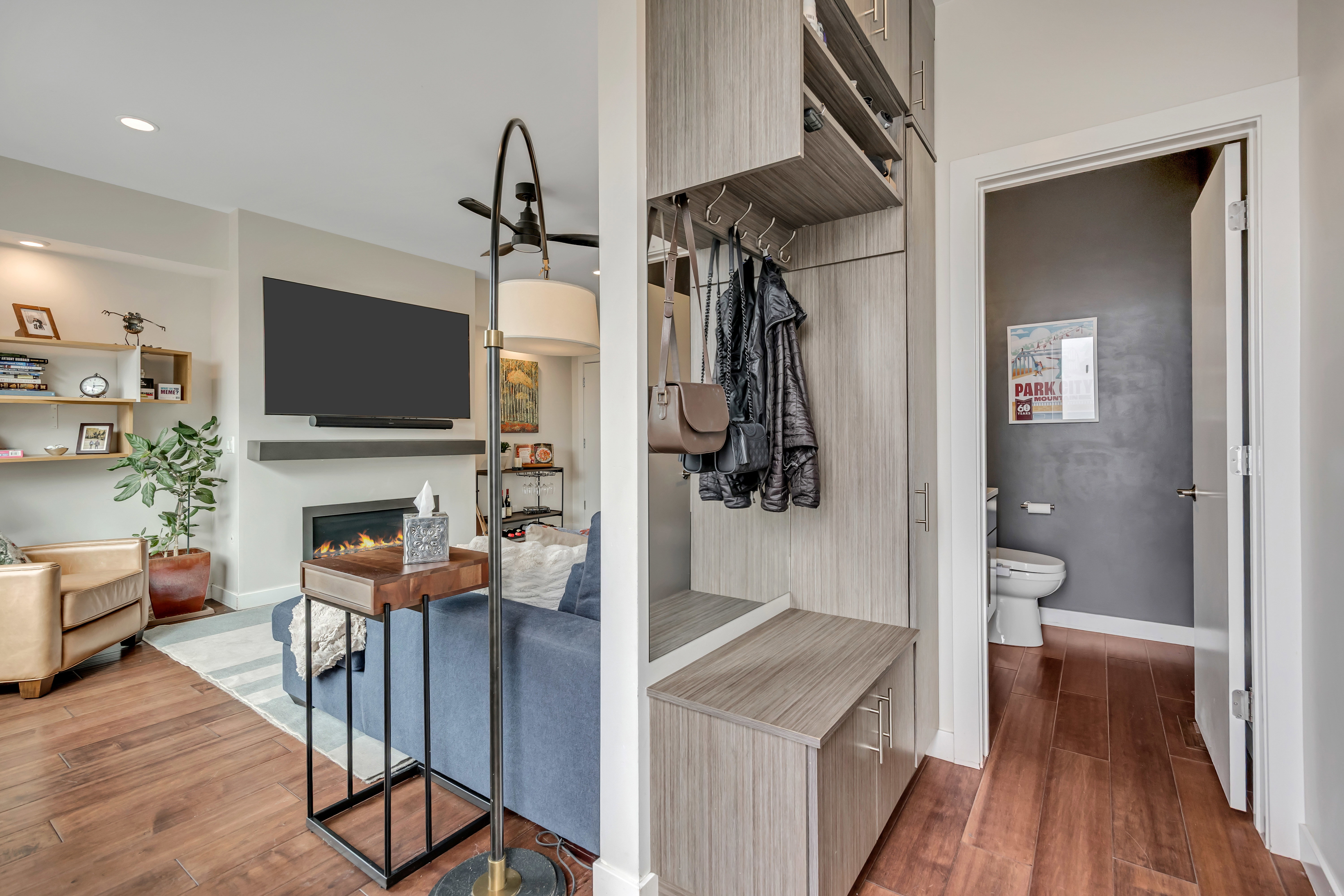 Mudroom with dark wood-style floors, a lit fireplace, and recessed lighting located near the backdoor entrance