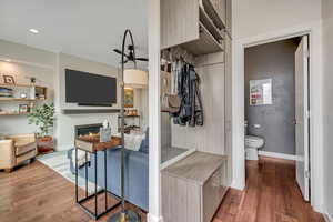 Mudroom with dark wood-style floors, a lit fireplace, and recessed lighting located near the backdoor entrance
