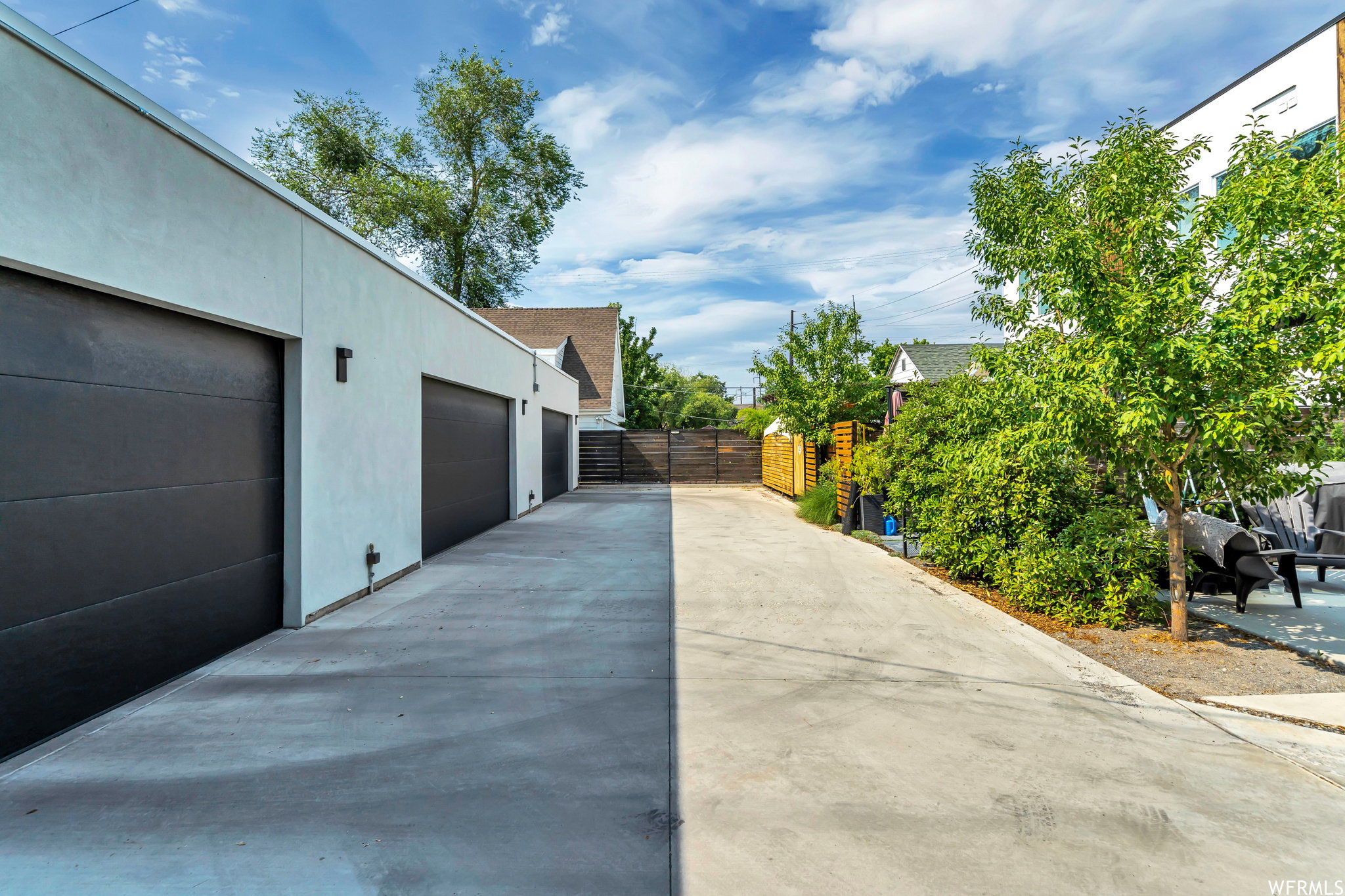View of home's exterior with stucco siding, driveway, and a gate