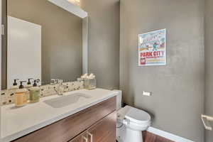 Half bath with baseboards and vanity located on the main level