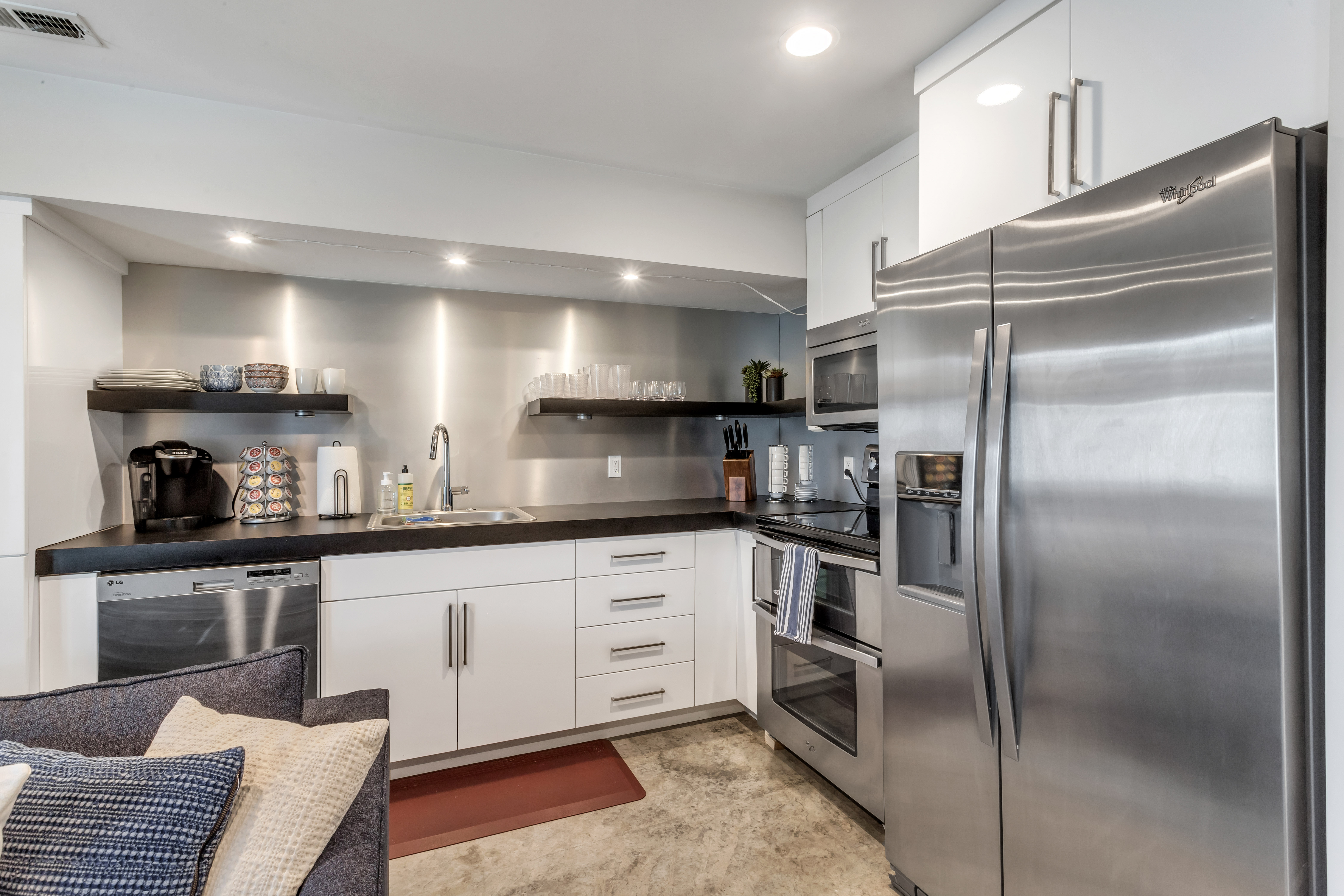 Kitchen featuring white cabinetry, stainless steel appliances, open shelves, recessed lighting, and dark countertops