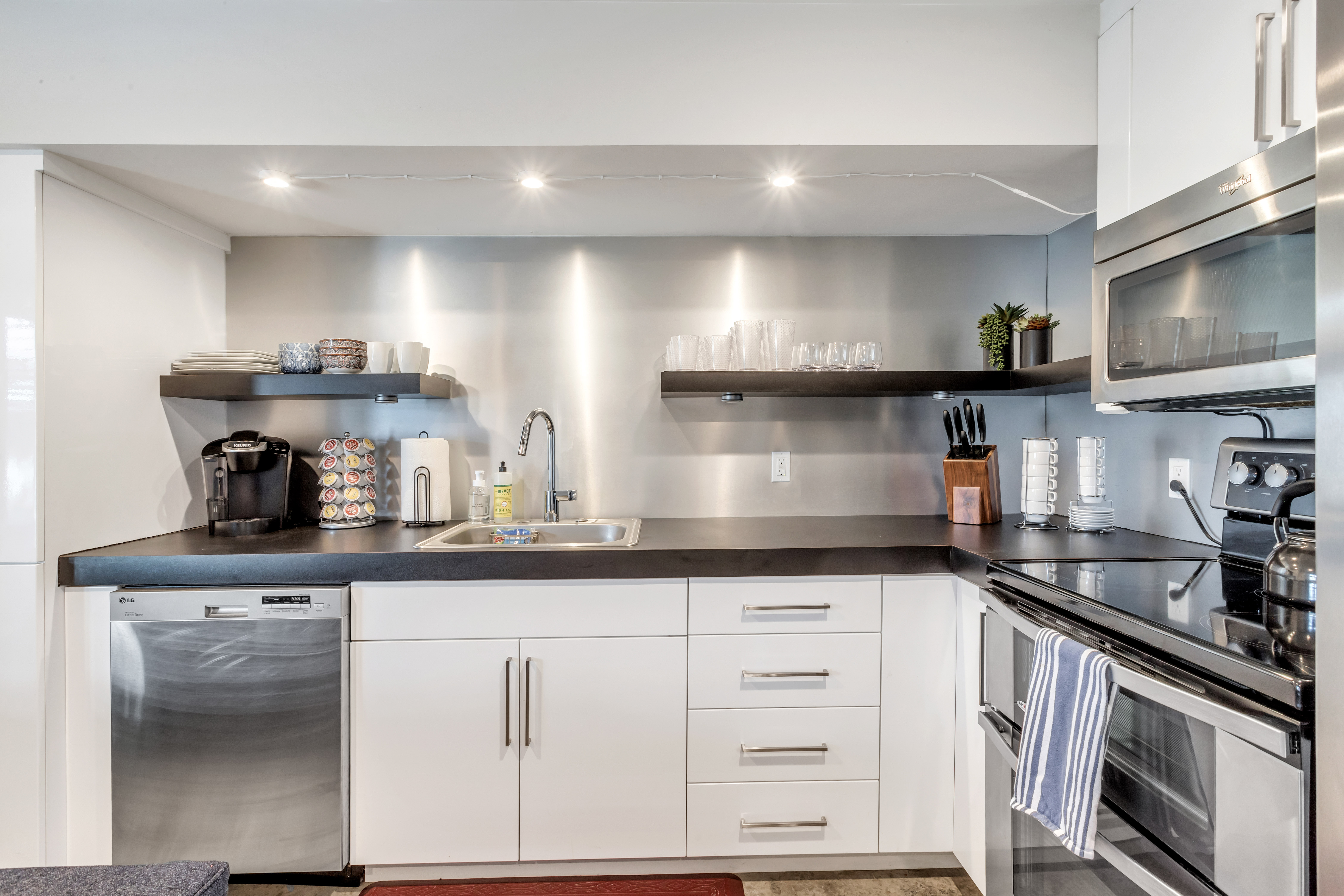 Kitchen featuring open shelves, white cabinetry, stainless steel appliances, dark countertops, and recessed lighting