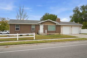 Single story home with brick siding, an attached garage, a chimney, entry steps, and driveway
