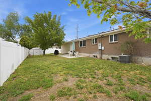 Rear view of house featuring a patio area, a storage shed, a fenced backyard, and brick siding