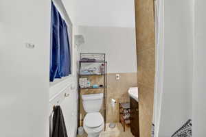 Bathroom featuring vanity, tile walls, and light tile patterned flooring