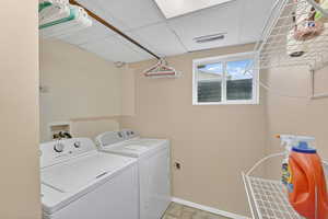 Laundry room featuring a paneled ceiling and washer and dryer