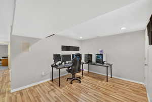 Office area with light wood finished floors and recessed lighting