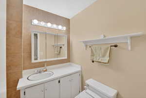 Half bath featuring vanity and tile walls