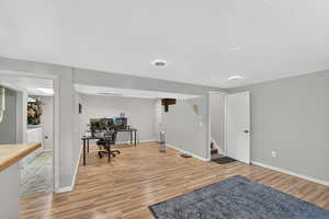 Home office with light wood-style floors and a textured ceiling