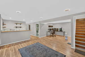 Bar area with light wood-style floors and recessed lighting